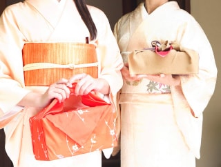 着物姿で手土産を持つ二人の女性